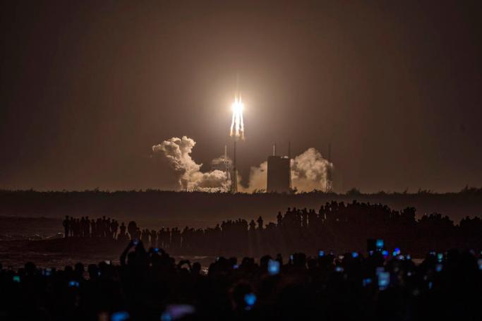 People watch a Long March 5 rocket carrying the Chang'e-5 lunar probe launching from the Wenchang Space Center in Wenchang, Hainan Island, China, 24 November 2020. Photo: EPA
