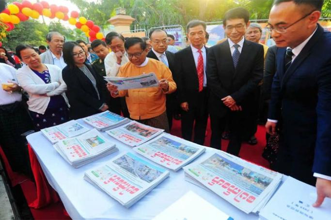 Chief Minister of Mandalay Region Dr. Zaw Myint Maung looks at a copy of Pauk Phaw newspaper at an event in January. (Photo: Pauk Phaw 胞波 Facebook) 