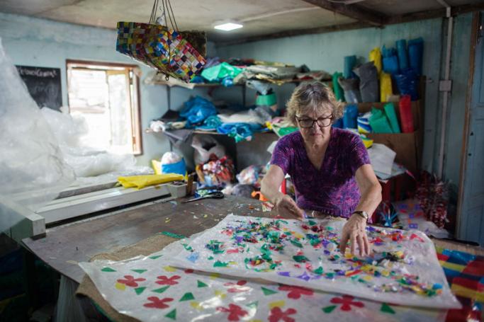 Debra Martyn, a volunteer from Canada, works on an art project using recycled plastic materials at a Chu Chu recycling shop in Dala, on the outskirts of Yangon, on June 4, 2018. Photo: Ye Aung Thu/AFP
