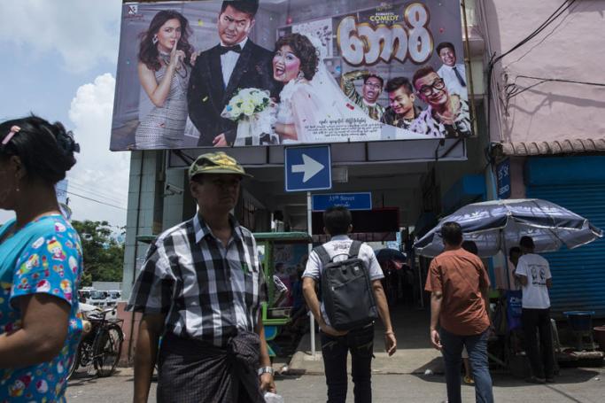 People walking by the Thwin cinema in downtown area of Yangon. Photo: Ye Aung Thu/AFP
