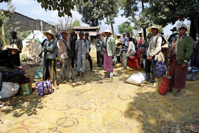 People gather as they wait the arrival of a rescue team to flee away from the Kokang capital Laukkai, northern Shan State, Myanmar, February 17, 2015. Photo: Lynn Bo Bo/EPA
