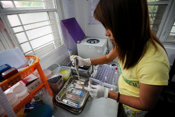 A medical technician testing a blood sample for HIV at a clinic in Yangon. Photo: AFP
