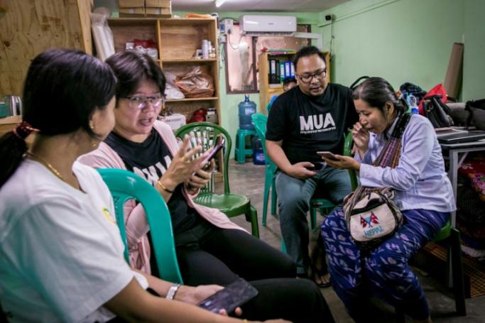 This photograph taken on September 22, 2019 shows Myanmar information technology volunteers assisting mobile phone users switching from the old Zawgyi font to the unicode font in Yangon. Photo: Sai Aung Main/AFP