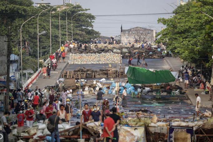 Demonstrators gather along barricades during a protest against the military coup in Yangon, Myanmar, 17 March 2021. Photo: EPA