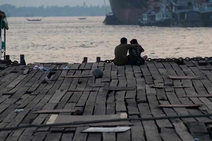 This photo is taken on April 26, 2017 shows a couple sitting at a jetty during sunset in Yangon. Photo: Ye Aung Thu/AFP
