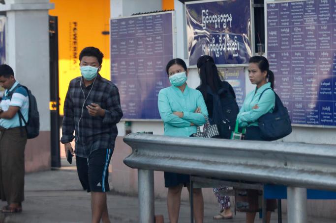 People wear masks as they stand outside a private hospital in Yangon. Photo: Nyein Chan Naing/EPA