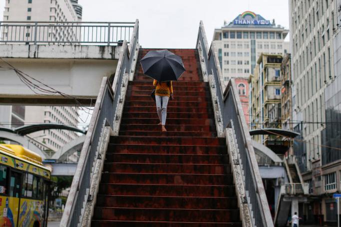 A girl walks down from a footbridge at downtown area despite the stay-at-home order to prevent the spread of COVID-19, Yangon, Myanmar, 21 September 2020. Photo: Lynn Bo Bo/EPA