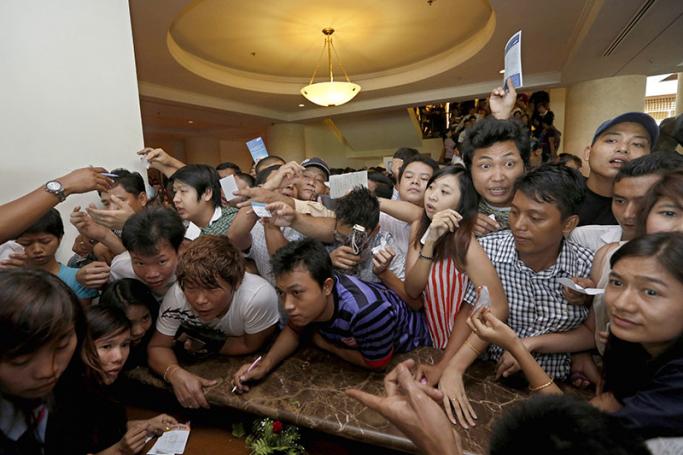 Crowds of young people crush the counter as they try to buy the new mobile handset in Yangon. Photo: Nyein Chan Naing/EPA
