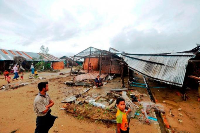 Residents survey the damage caused by cyclone Komen that swept across western Myanmar. Photo: WFP
