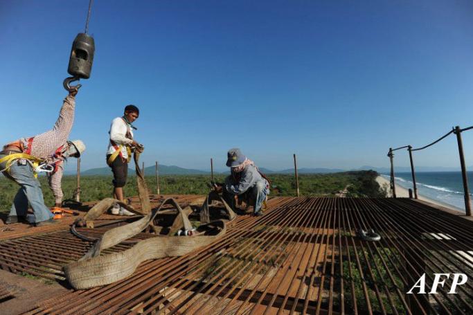 Construction labourers working on an elevated platform at a deep sea port project in Mayingyi, part of the Dawei Special Economic Zone development.  Photo: Soe Than Win/AFP
