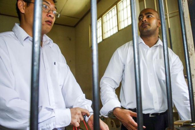 Australians Mr Andrew Chan (L) and Mr Myuran Sukumaran (R) inside a holding cell waiting for trial at a Denpasar District Court in Bali, Indonesia. Mr Chan, 31, and Mr Sukumaran, 34, are the only members of the so-called Bali Nine drug smuggling ring on death row for trying to smuggle 8.3 kilogrammes of heroin from the Indonesian resort island of Bali to Australia in 2005. Photo: Made Nagi/EPA
