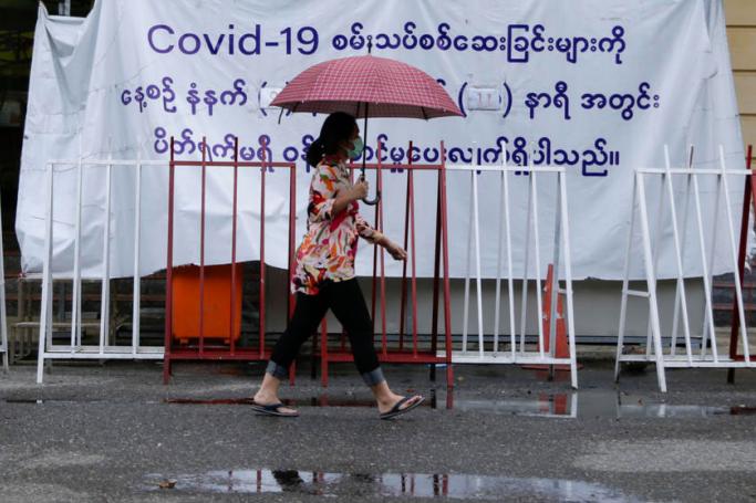 (File) Myanmar woman walks pass in front of the COVID-19 test center at downtown area of Yangon, Myanmar, 10 June 2021. Photo: EPA
