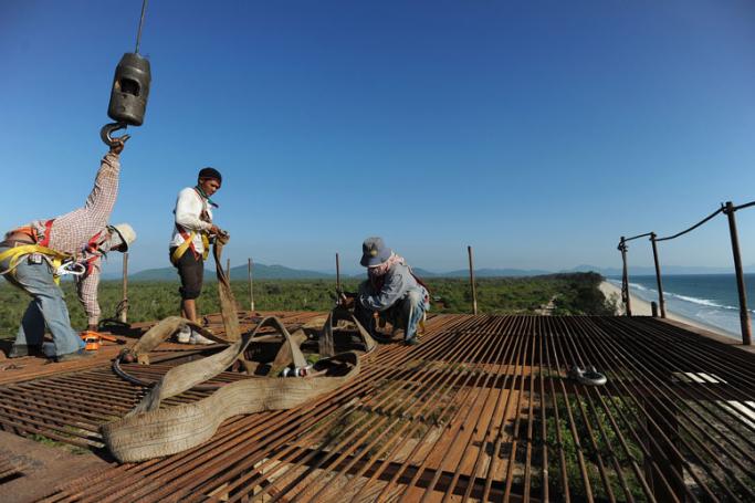(File) Construction labourers working on an elevated platform at a deep sea port project in Mayingyi, part of the Dawei Special Economic Zone development. Photo: AFP