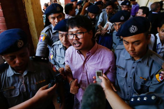 Detained Reuters journalist Wa Lone (C) is escorted by police as he arrives at the court for his trial in Yangon, Myanmar, 16 May 2018. Photo: Lynn Bo Bo/EPA-EFE
