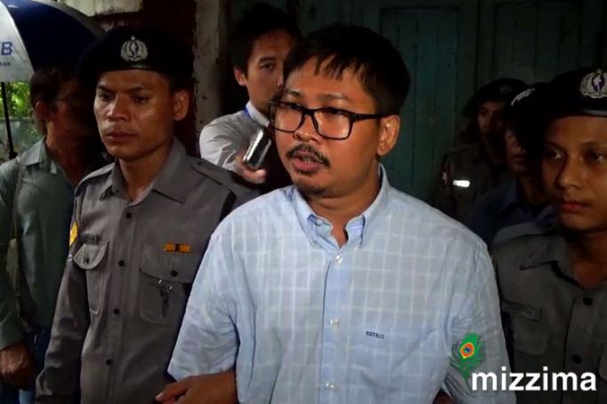 Detained Reuters journalist Wa Lone (C), escorted by the police as he leaves the court on their trial in Yangon, Myanmar, 18 June 2018. Photo: Mizzima
