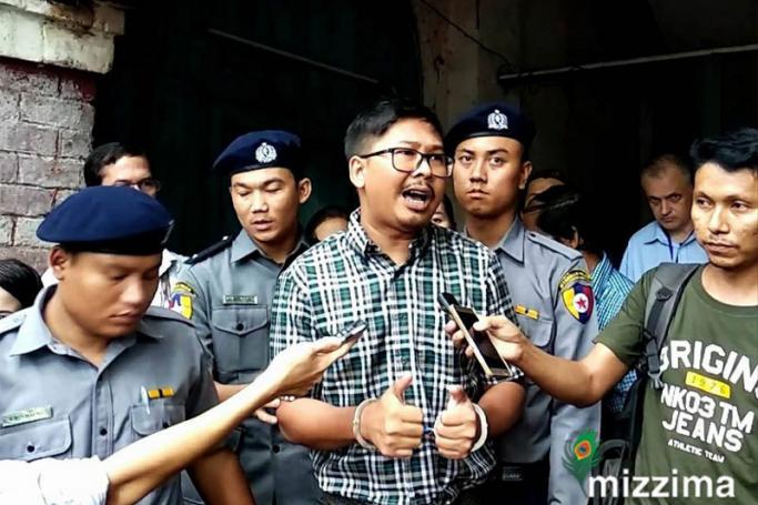 Detained Reuters journalist Wa Lone (C) escorted by police as he talks to media after his trial at the court in Yangon on 12 June 2018. Photo: Ye Naing/Mizzima
