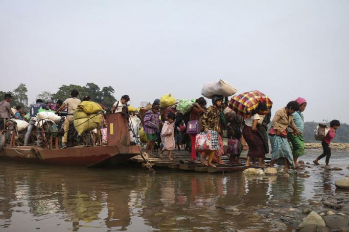 This picture taken on April 26, 2018 shows displaced Kachin residents crossing Malikha river on a ferry to escape the fighting in Injanyan village near Myitkyina between the Kachin Independence Army, ethnic armed group against the Myanmar government troops in Myanmar's northernmost state of Kachin near the border with China. Photo: Zau Ring Hpara/AFP
