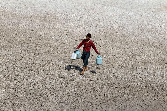 Problem of droughts - A boy carries buckets to collect drinking water at Sapa village, in the outskirts of Mandalay, Myanmar, 23 February 2016. Photo: Hein Htet/EPA
