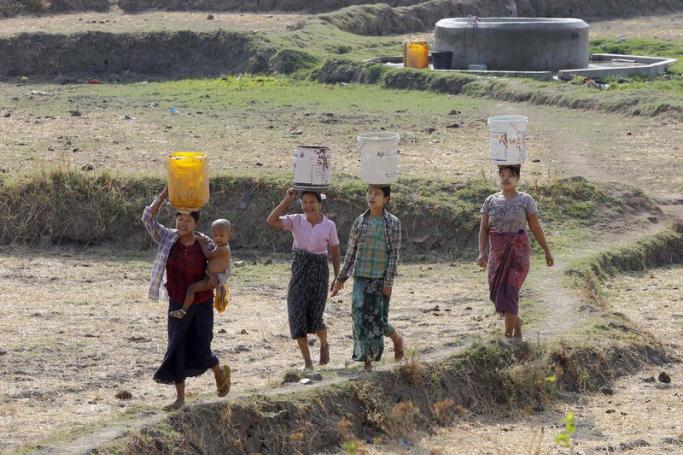 (File)  Myanmar women carrying buckets on their heads collect drinking water from the outskirts of Naypyitaw, Myanmar, 25 April 2016. Photo: EPA