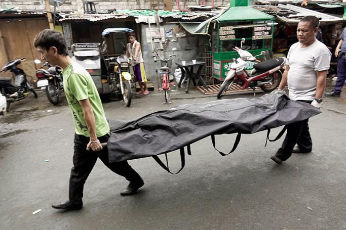 Filipino funeral parlor wokers carry a dead body following a police operation against illegal drugs in Manila, Philippines, 08 December 2016. Photo: Francis R. Malasig/EPA
