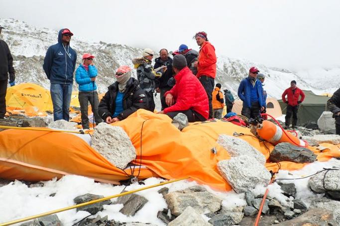 Climbers in the debris of the Mount Everest base camp after it was hit by an avalanche that killed at least 18 people following the 7.9 magnitude earthquake in Nepal, 25 April 2015 (picture made available 26 April 2015). The avalanche that swept through parts of base camp is reported having had the combined force of two separate snowslides from different peaks. EPA/AZIM AFIF Courtesy of Azim Afif
