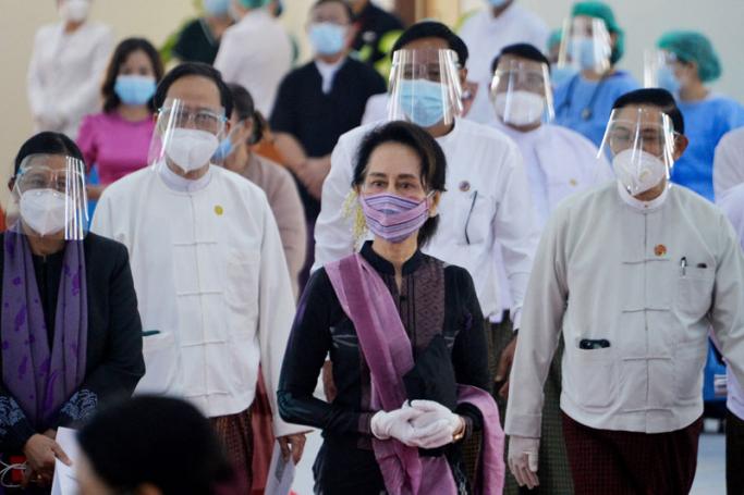 (FILE) In this file photo taken on January 27, 2021, Myanmar's State Counsellor Aung San Suu Kyi (C) looks on as health workers receive a vaccine for the Covid-19 coronavirus at a hospital in Naypyidaw. Photo: AFP