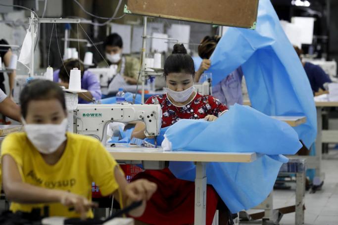 Workers make disposable surgical gown at a garment factory in Yangon, Myanmar. Photo: EPA