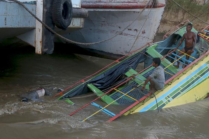 Local rescue workers sit on apart of a sunk ferry boat on the Chindwin river near the city of Monywa, Sagaing Division, Myanmar, 18 October 2016. Photo: EPA
