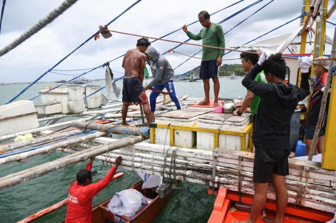  In this photo taken on August 10, 2022, fisherman Christopher de Vera (C, in green shirt) supervises the loading of ice and provisions to their fishing “mother” boat in the village of Cato, Infanta town, Pangasinan province, as he and his crew prepare to leave for a fishing expedition to the South China Sea. Photo: AFP