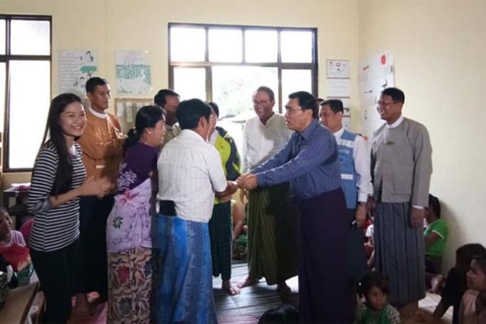 Union Minister Dr. Win Myat Aye, centre-right, accepts a cash donation for families residing at temporary relief camps due to flash floods occurring in their homes in Mottama of Mon State. Photo: MNA
