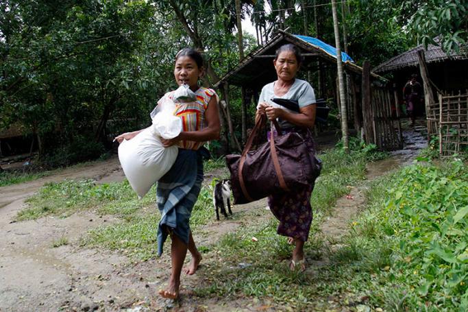 Villagers carry belongings as they prepare to flee from fighting at Aung Mingalar village near Maungdaw town of Bangladesh-Myanmar border, Rakhine State, western Myanmar, 13 October 2016. Photo: Nyunt Win/EPA
