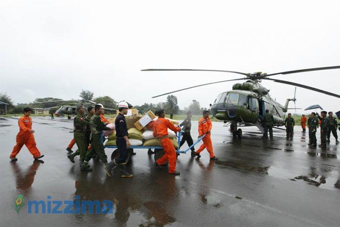 Soldiers and rescue workers carry aid near a military helicopter in Sittwe airport, Rakhine State on August 4, 2015. Photo: Hong Sar/Mizzima
