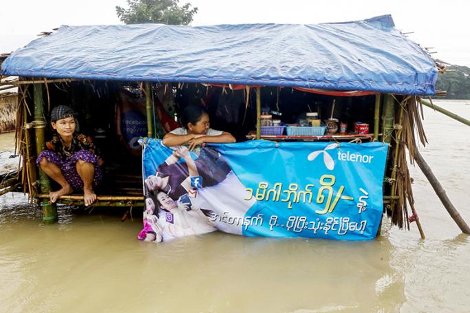 Women sit in their half-flooded temporary shelter near the flooded Yangon-Pathein highway road near Darka town of Ayeyarwady Region, Myanmar, 12 August 2016. Photo: Lynn Bo Bo/EPA

