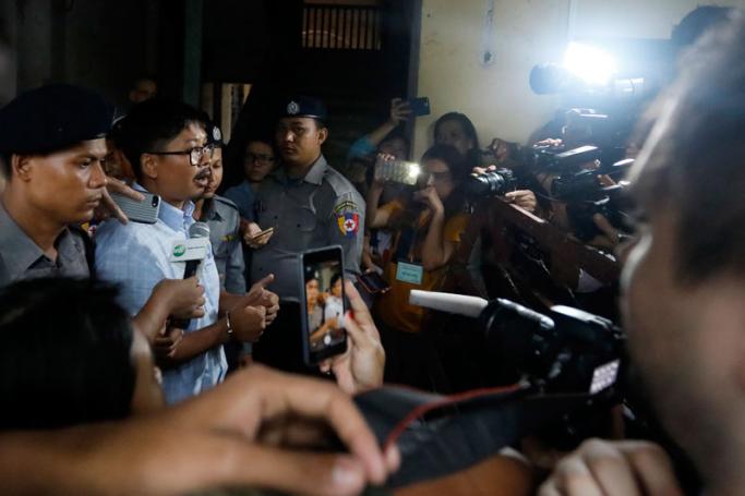 Detained Reuters journalist Wa Lone (2-L) is escorted by the police, as he talks to members of the media while leaving the court in Yangon, Myanmar, 18 June 2018. Photo: Nyein Chan Naing/EPA-EFE
