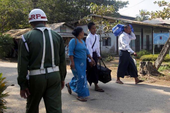 (File) Myanmar boy wearing white shirt (2R), who was discharged from Myanmar army, walks together with his parents as they walk pass near a military man at a gate of military compound after the ceremony on handover discharged minor to parents (or) guardian in Yangon, Myanmar, 18 January 2014. Photo: Lynn Bo Bo/EPA