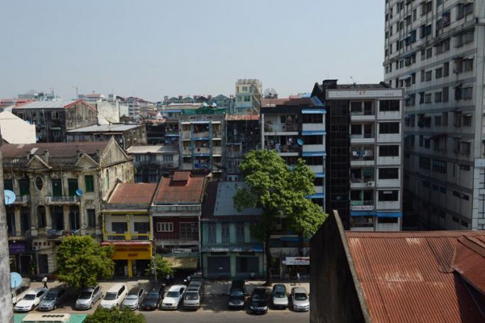 A general view shows a colonial era building (seen at left) standing near a newly constructed high rise apartment block in Yangon. Photo: AFP