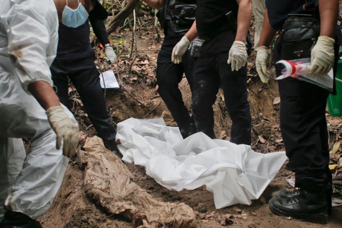 Members of Royal Malaysia Police forensic team exhume human remains from a grave found at Wang Burma hills at Wang Kelian, Perlis, Malaysia, 26 May 2015. Photo: Fazry Ismail/EPA
