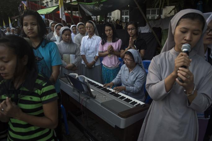 A Catholic nun plays the keyboard whilst worshippers sing during morning prayers at St. Francis of Assisi Catholic Church in Yangon on November 28, 2017, a day after the arrival of Pope Francis to the country. Photo: Lillian Suwanrumpha/AFP
