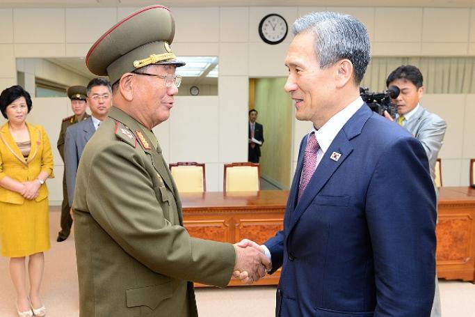 A photo released by the South Korean ministry via Yonhap News Agency (YNA) shows South Korean National Security Adviser Kim Kwan-jin (R) and Hwang Pyong-so, the North Korean military's top political officer, shaking hands after completing the inter-Korean high-level talks at the truce village of Panmunjom inside the Demilitarized Zone, on 25 August 2015.

