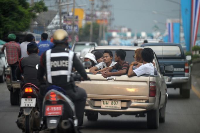 File photo handcuffed Myanmar migrants (C) sitting at the back of a pick-up truck after they were rounded up by Thai police in Mahachai, an industrial area south of Bangkok. Photo: AFP
