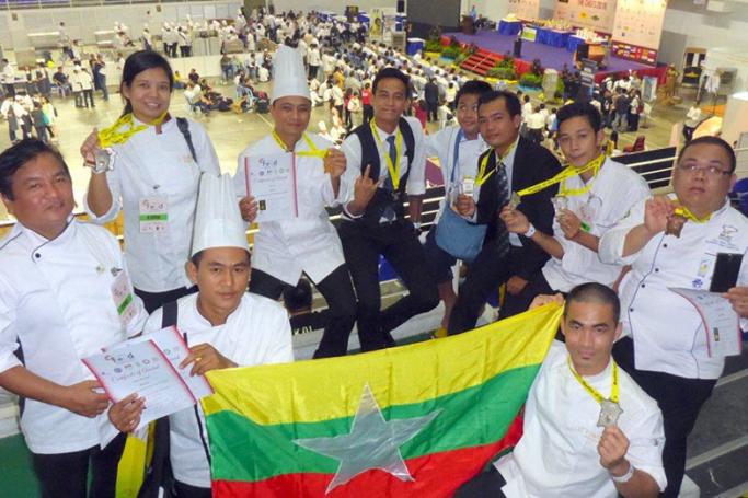 The winners display the Myanmar flag at the event in Malaysia. 
