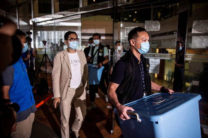 A police officer (R) from the National Security Division leaves the Hong Kong University Students’ Union building with a box after conducting a search in Hong Kong on July 16, 2021. Photo: AFP