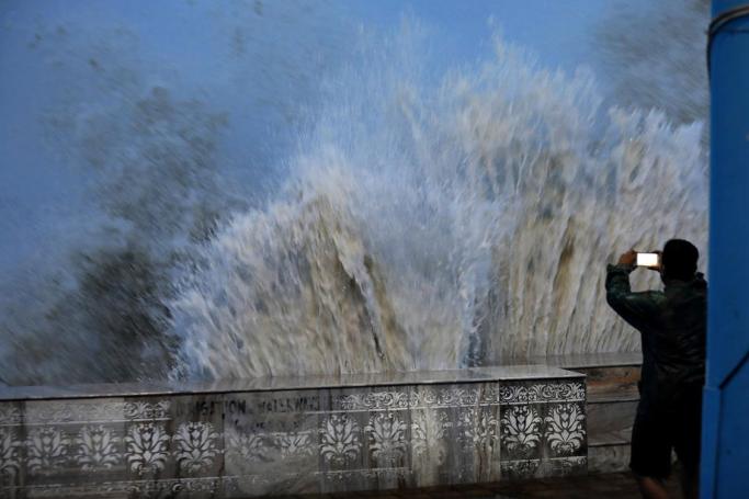 A man takes photos of a high tide seen in the Bay Of Bengal before Cyclone Yaas arrives in Digha, 205km South of Kolkata, Eastern India, 25 May 2021. Photo: EPA