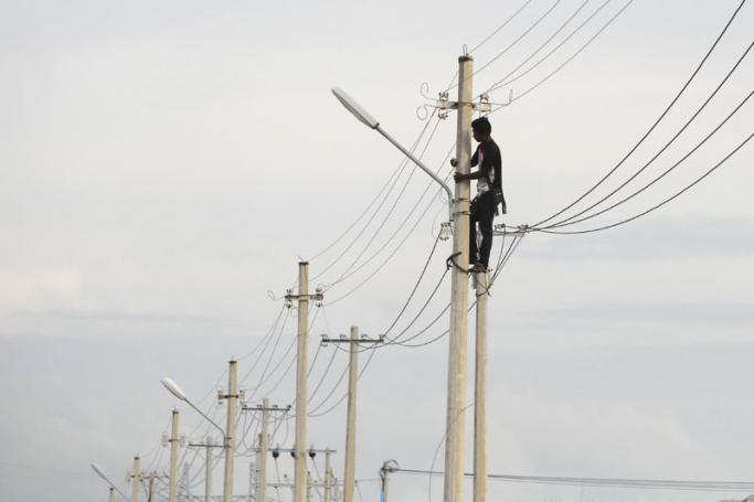 A technician works on electric power cables in Naypyitaw, Myanmar. Photo: Hein Htet/EPA
