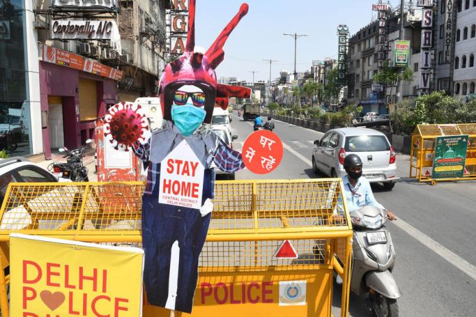 A motorist passes by a cutout placard placed on police barricade as part of an awareness campaign over coronavirus pandemic, in New Delhi, India, 15 May 2020. Photo: EPA