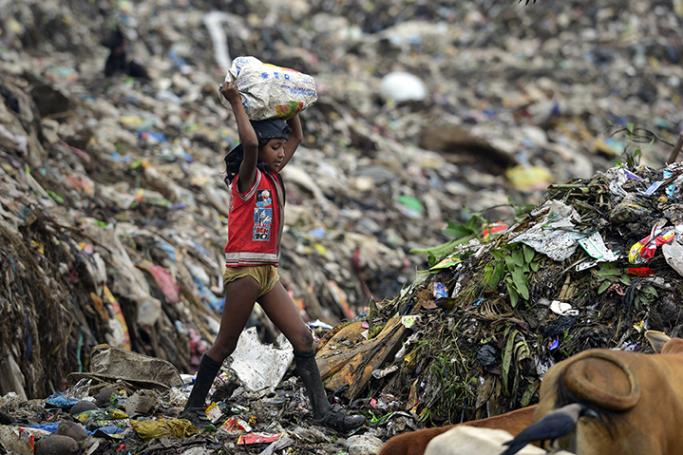 Eliminating poverty is proving a tough call - An Indian girl collecting rubbish at a garbage landfill site near Guwahati city in Assam, India. Photo: EPA
