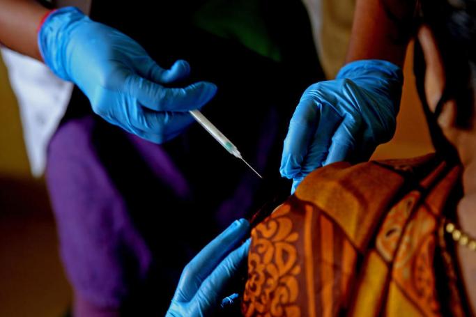 An Indian woman receives a shot of COVID-19 vaccine during the vaccination drive at CV Raman General Hospital in Bangalore, India. Photo: EPA