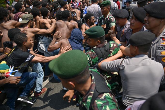 Papuan students taking part in a rally push toward a line of police and military blocking them in front of the army's headquarters in Jakarta on August 22, 2019, as riots and demonstrations have brought several cities in Indonesia's eastern province of Papua to a standstill this week. Indonesia has blocked internet access in unrest-hit Papua over fears that a stream of offensive and racists posts online will spark more violent protests in the region, the government said on August 22. Photo: Bay Ismoyo/AFP
