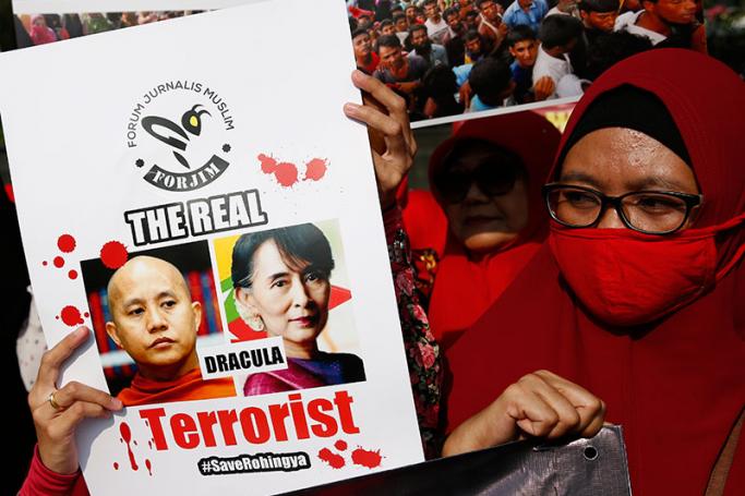 Indonesian Muslim activists hold a protest banner showing Myanmar State Counsellor Aung San Suu Kyi (R) and Myanmar nationalist Buddhist monk Wirathu (L) during a protest against Myanmar's alleged persecution of its Muslim Rohingya minority at a main roundabout in Jakarta, Indonesia, 03 September 2017. Hundreds of Muslim activists staged a rally condemning the Myanmar government for its purported ongoing persecution of the Muslim Rohingya minority. Photo: Adi Weda/EPA
