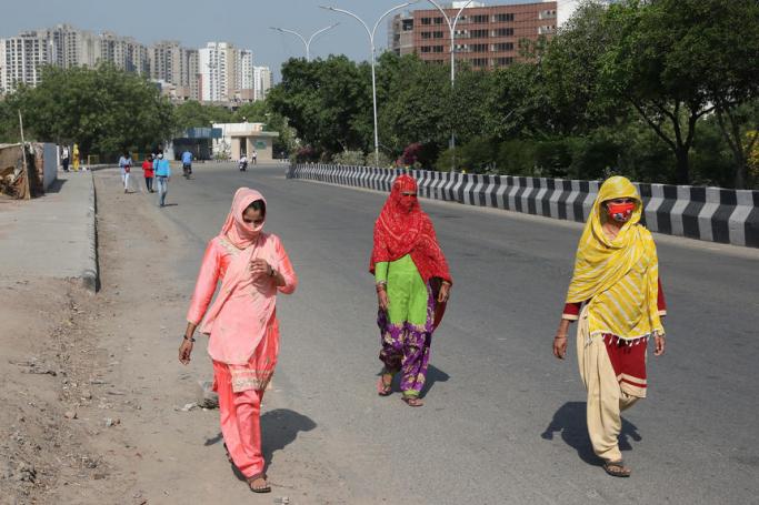 Workers walk on the road to reach their factories and work places in Noida outskirts of New Delhi, India, 05 May 2020. Photo: EPA